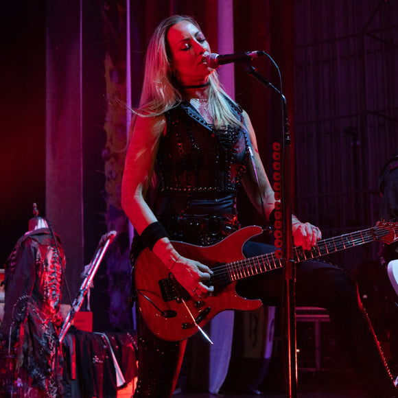 Guitarist Nita Strauss performing live on stage.