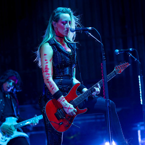 Guitarist Nita Strauss performing live on stage.