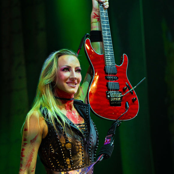 Guitarist Nita Strauss performing live on stage.